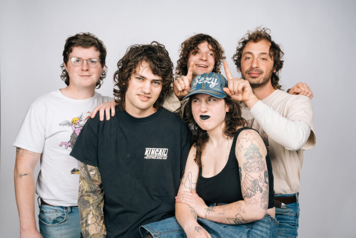 Five people stand together and pose for a photo.