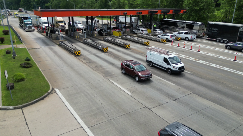 Cars and trucks going through several lanes of a toll booth
