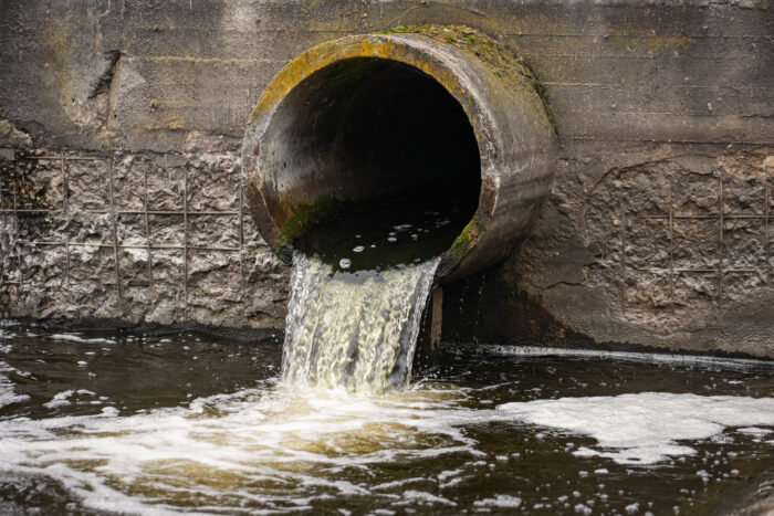 Water flowing from a drain pipe into a stream