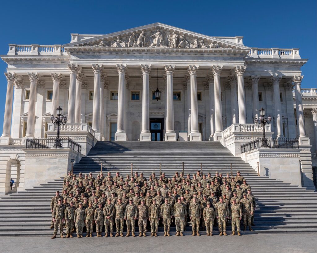 A group of soldiers stand outside a large Capitol building in Washington D.C.