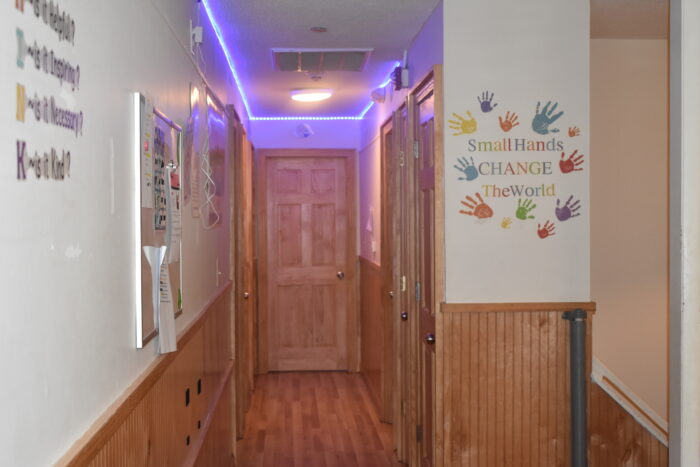 A brightly lit hallway is shown with inspirational quotes and colorful decorations on the walls.