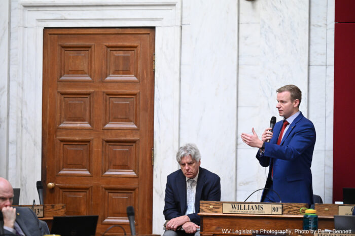Young man, blonde in blue suit, speaking in the House of Delegates