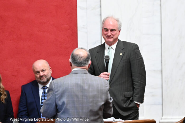 two men debate, one is holding a microphone.