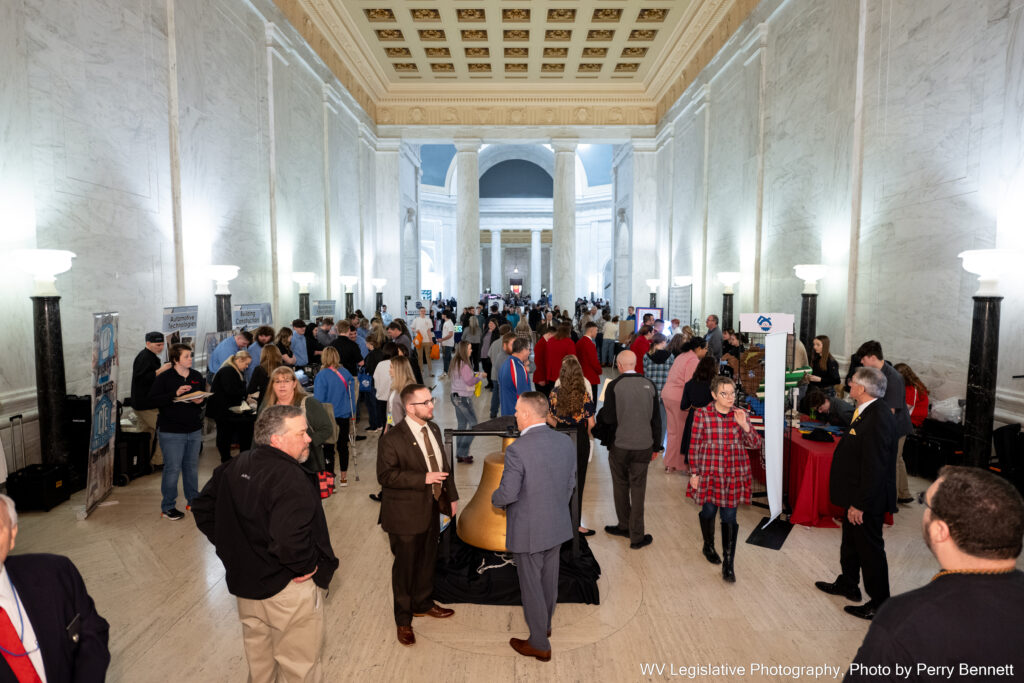 Lawmakers and visitors chat around vendor booths advertising career and technical programs from a variety of West Virginia schools.