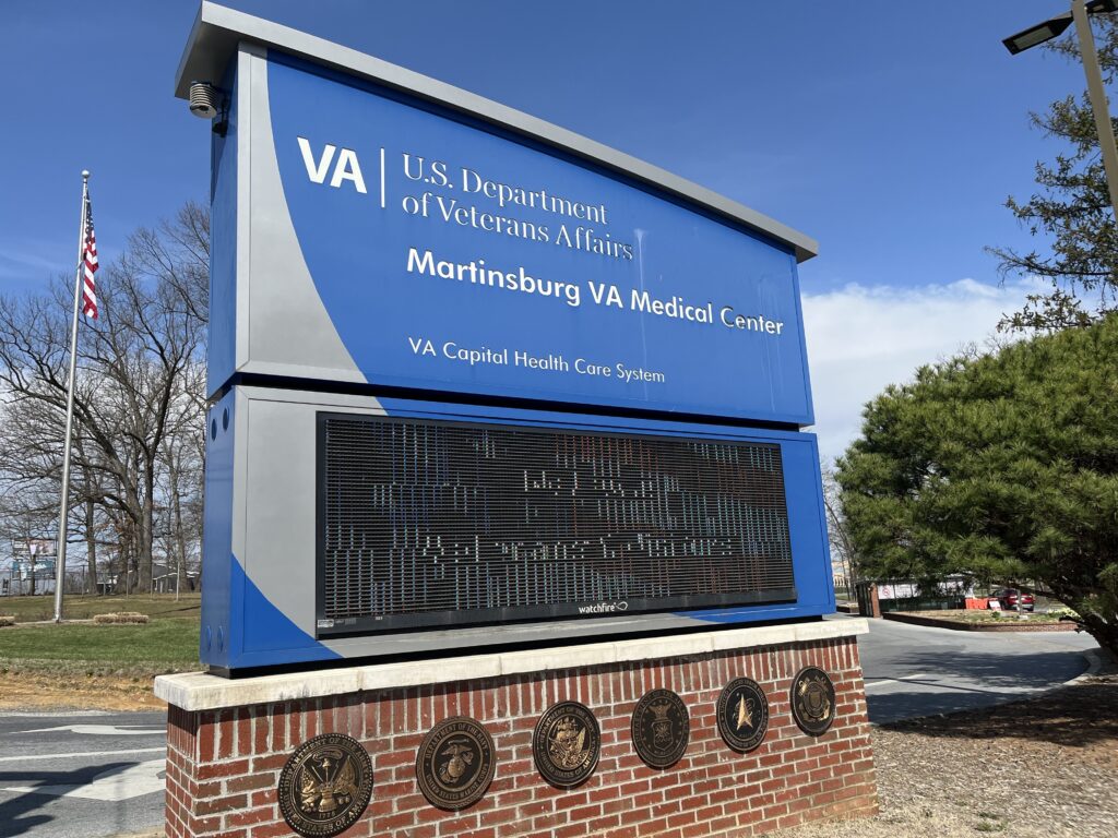 A sign outside of the Martinsburg VA Medical Center, which also displays an electronic panel that displays a rotation of messages.