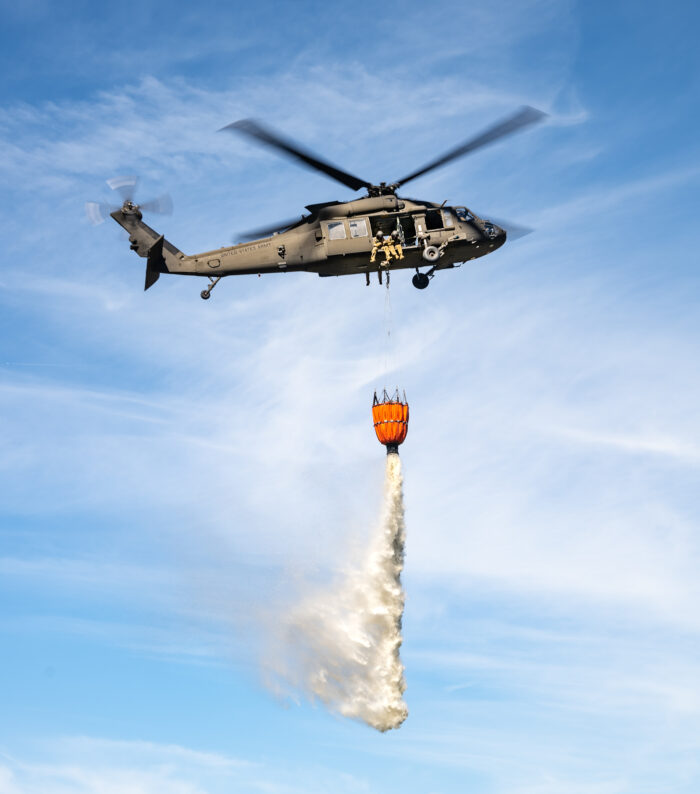 From a helicopter, the National Guard drops water from the sky.