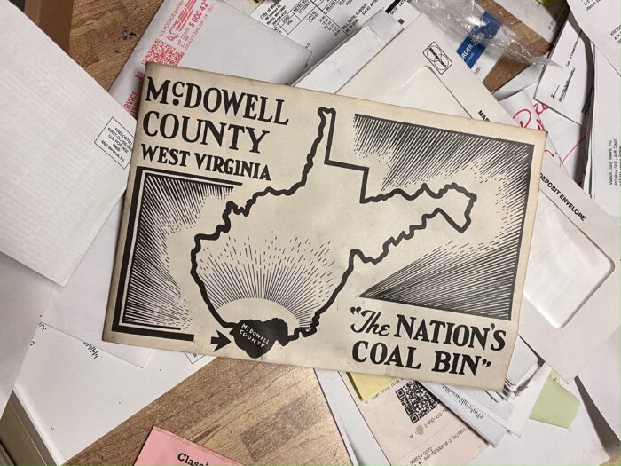 A stack of papers including mail and something that reads, "McDowell County, West Virginia. The Nation's Coal Bin."