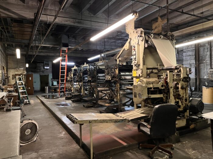 A large room can be seen with printing presses.