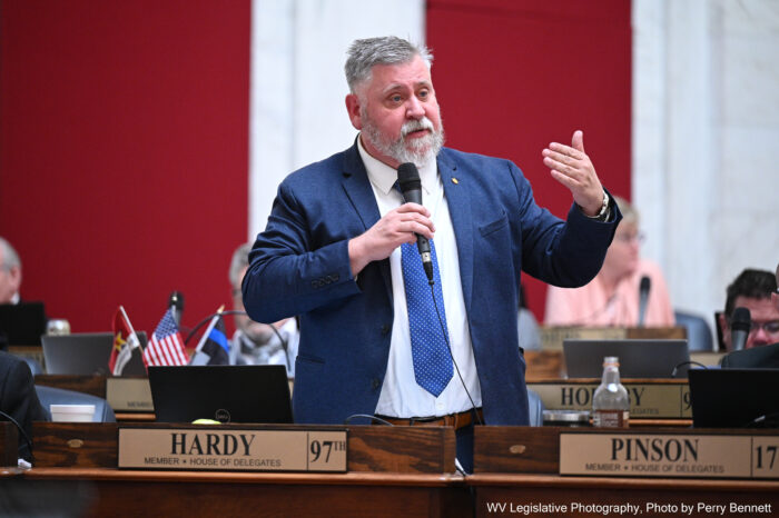 Man with goatee in suit speaking to room full of people.