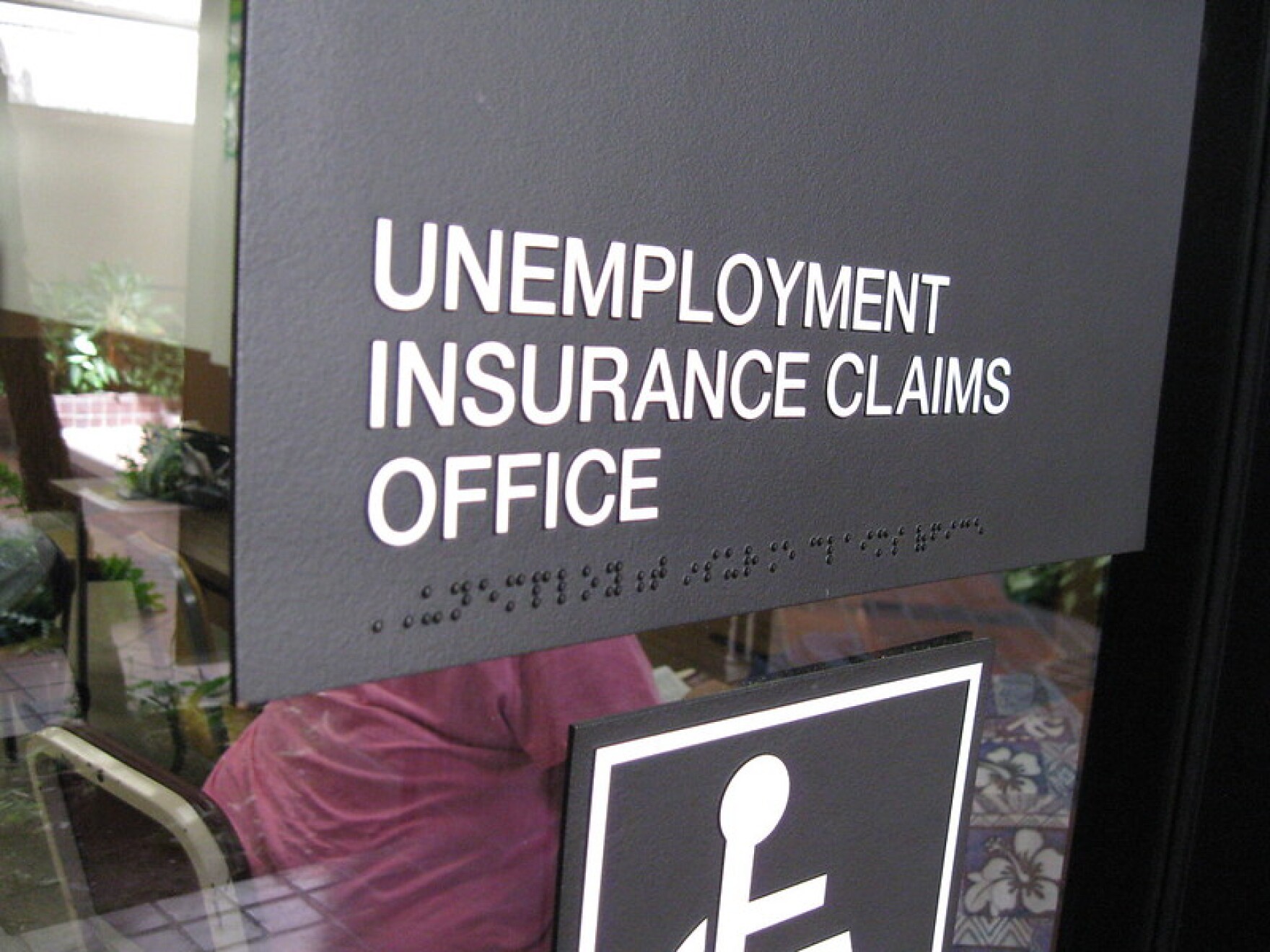 A sign outside an office window reads "Unemployment Insurance Claims Office."