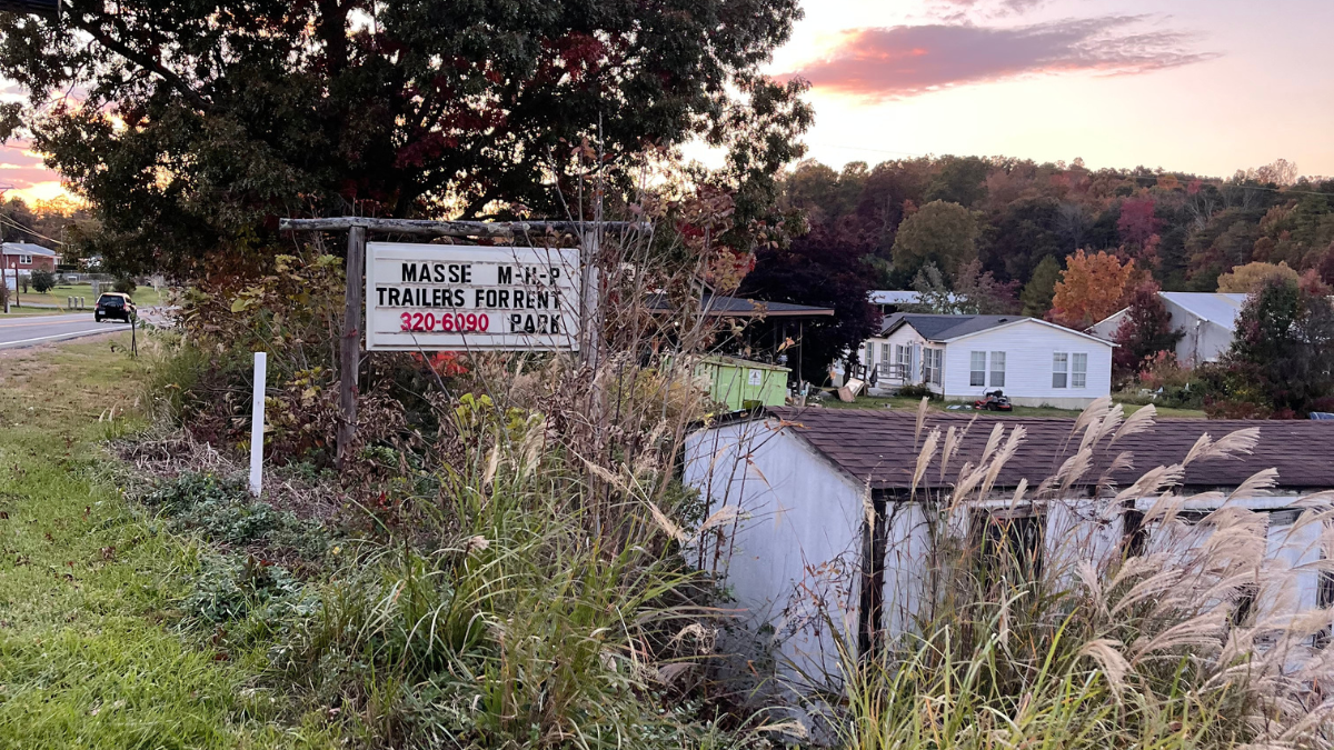 A sign is shown above several mobile homes in a mobile home park. The sign reads, "Masse Trailers for Rent, Park, 320-6090."