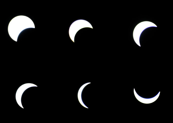 Six white discs on a black background show the progression of the eclipse April 8, 2024. The top left disc is the least obscured, with only a portion of the bottom right of the disc obscured by a black crescent. The top middle disc is further obscured, showing a slimmer crescent in the top left of the circle. The top right disc is still further obscured, appearing as a solid crescent of white. Bottom left the progression continues with an even narrower crescent of light in the left of the white disc. The bottom middle disc is a sliver of white, and the progression ends in the bottom right conrer as the crescent shifts from the left to the bottom of the white disc, indicating the moon has started to move away from the sun.