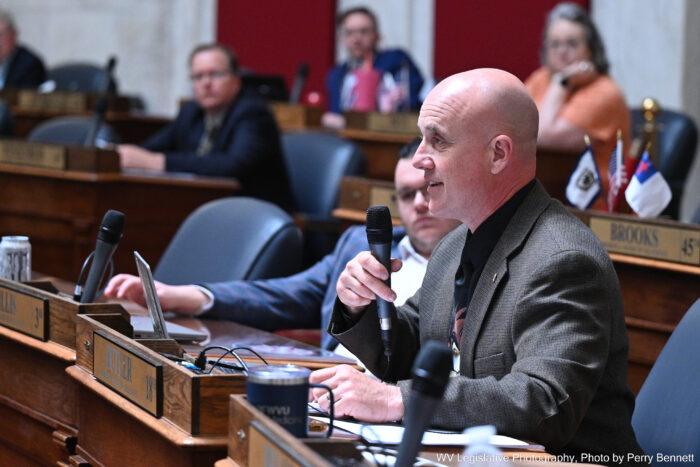 Bald man in suit speaking into a microphone