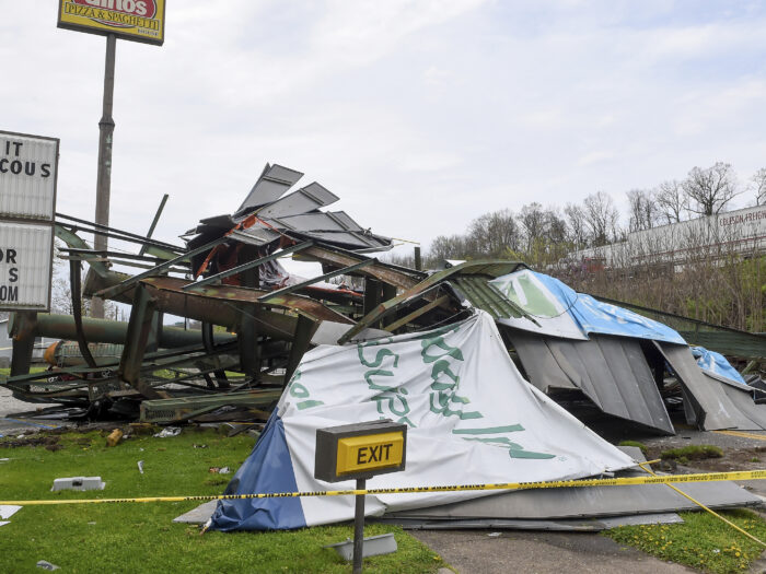 A billboard lay in ruins in a pile with metal posts.
