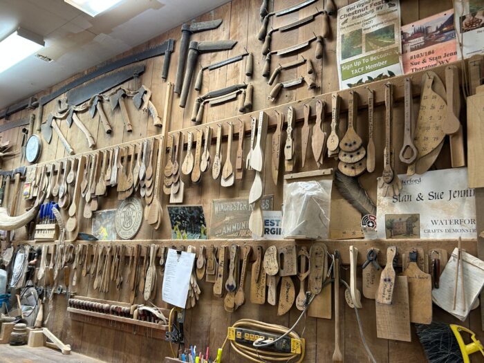 A wall chock full of handing wooden spoons - in all shapes and sizes.