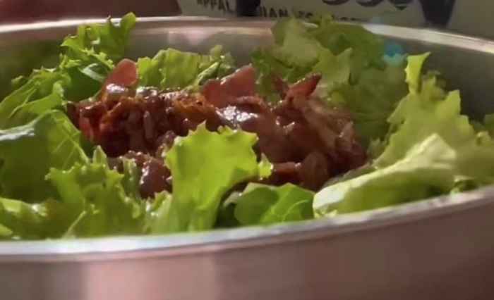 A close up video screenshot of a salad with onions.