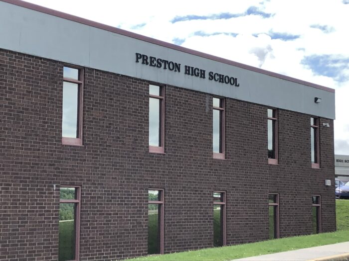A school building with the words "Preston High School" on the front. 