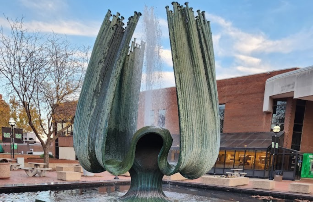 Tall tulip shaped green fountain spraying water into the air