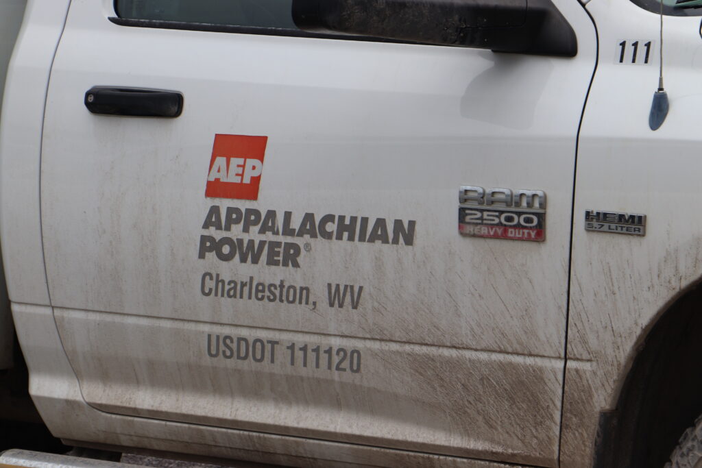 A white utility truck with black and red lettering.