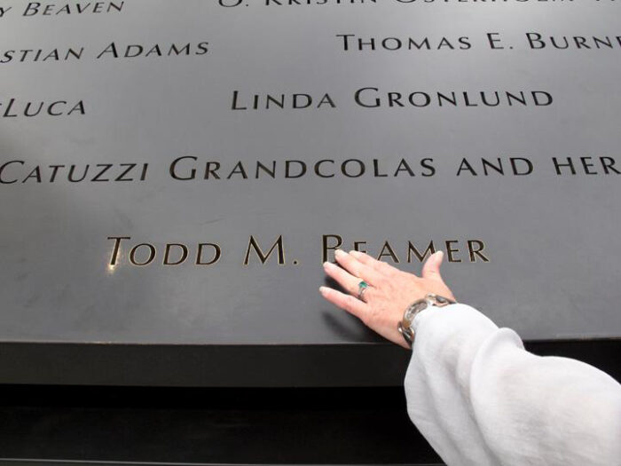 hand touches name engraved in memorial