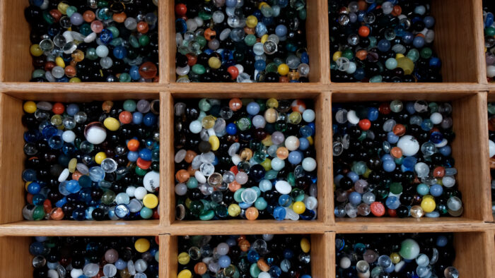 Wooden bins of many, colored marbles.
