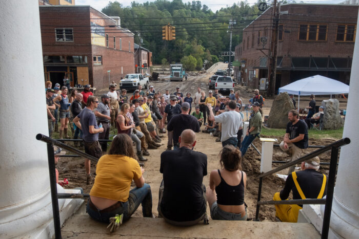 A crowd gathers outside a courthouse after a flood.