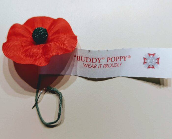 A red poppy worn as a symbol of remembrance