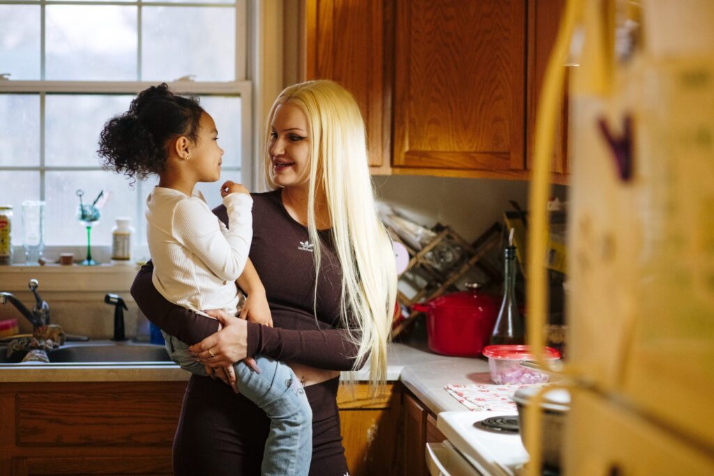 Young mother holding her child in a kitchen