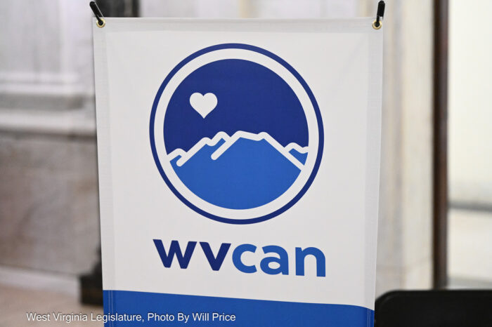 A blue and white poster displays an emblem of mountains and the letters "WVCAN."