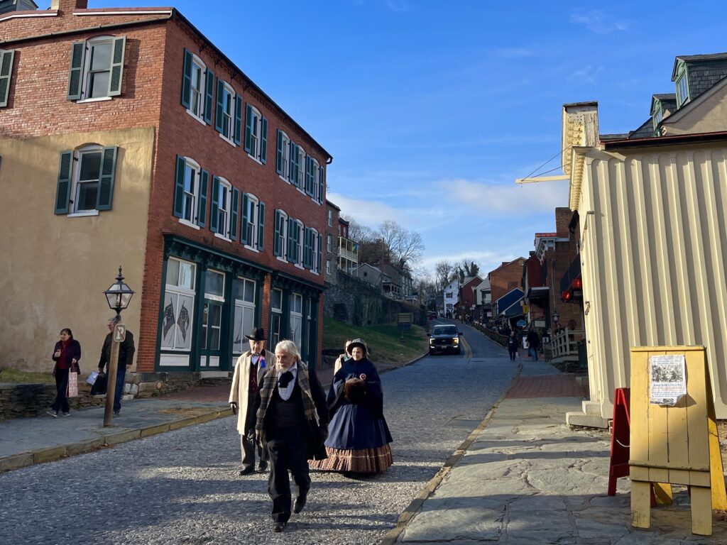 People dressed in colonial-era attire walk through the historic streets of Harpers Ferry in Jefferson County.