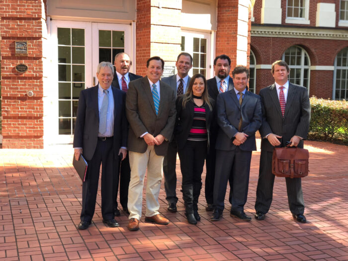 Eight people standing in front of a building.
