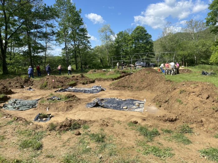 wide view of people and trenches on an archeological site.