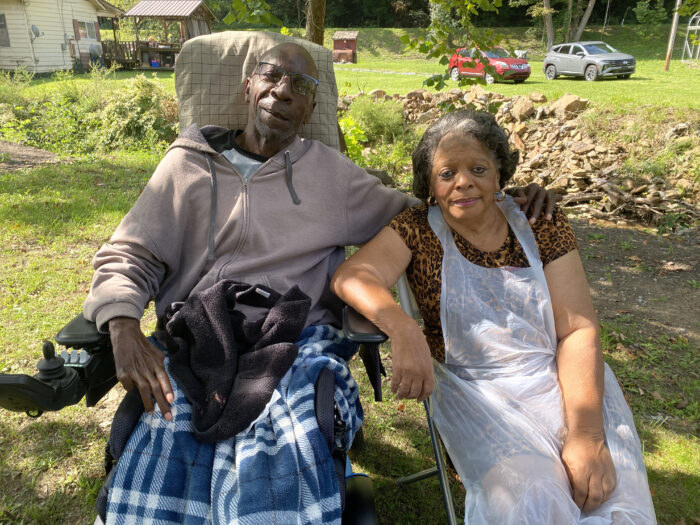 Two people sitting in chairs outside. 