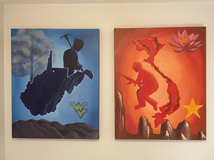 Two paintings hang on a wall. The painting on the left shows an outline of the state of West Virginia and the silhouette of a coal miner. The painting on the right depicts the outline of Vietnam and the silhouette of a soldier.
