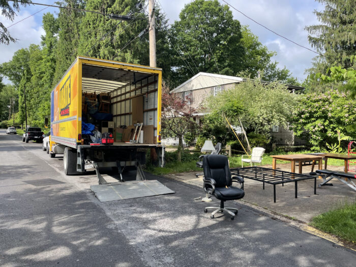 The back of an empty moving van on a sunny day.