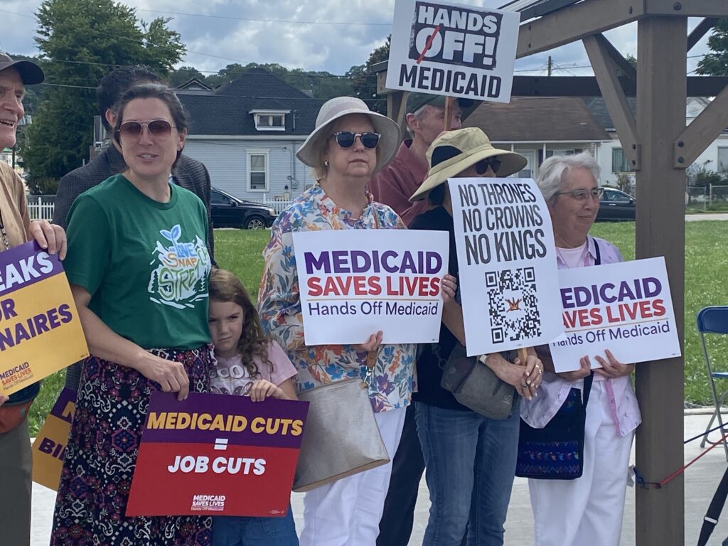 A variety of people standing in a line with signs