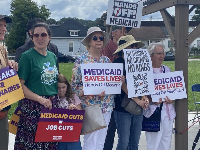 A variety of people standing in a line with signs