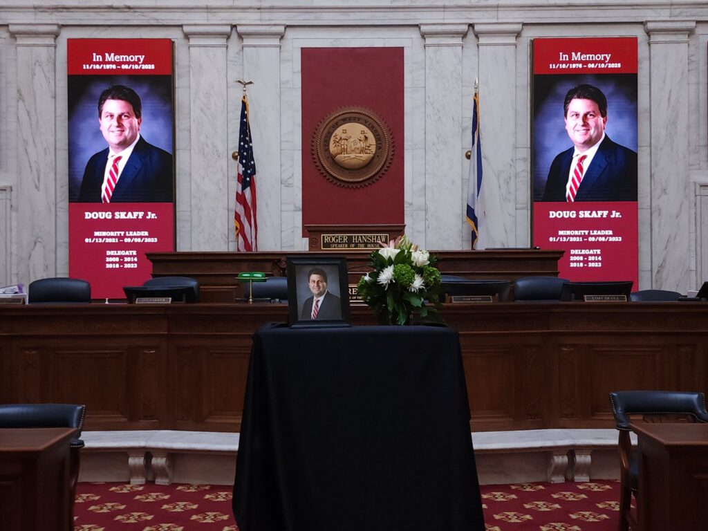 Photos and banners of a man in a dark suit on a table draped in black