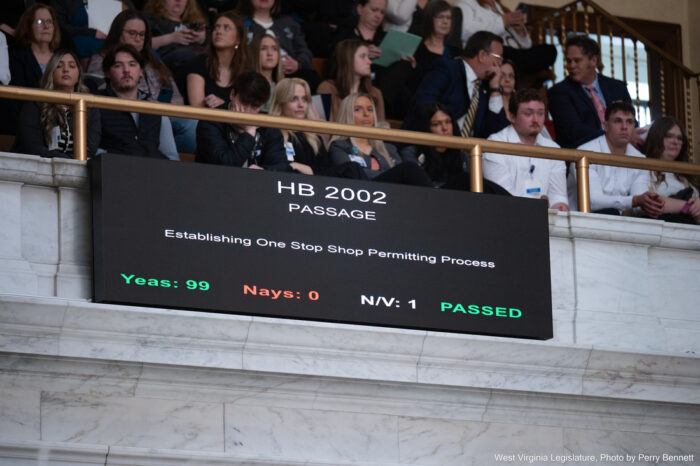 A screen displays the text "House Bill 2002" and shows a majority of lawmakers voted in favor of it.