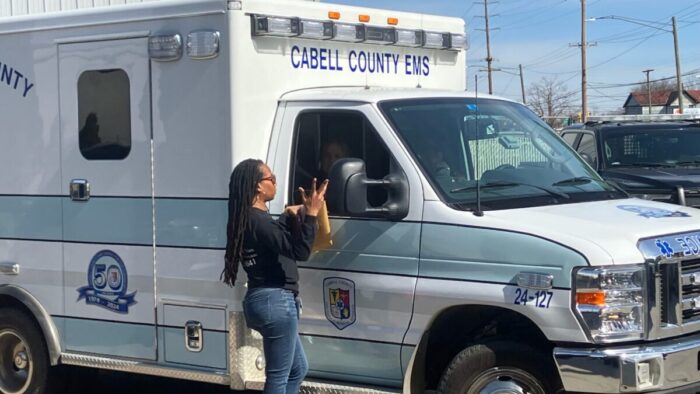 A woman standing next to an ambulance.