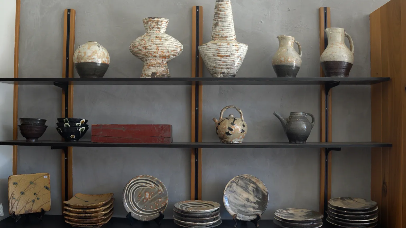 A shelf with finished pieces of pottery. 