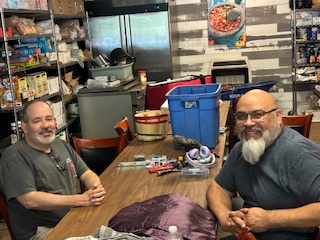 Two men sit across a table 