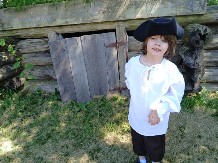 A young boy dressed up in colonial clothing for a reenactment video shoot.