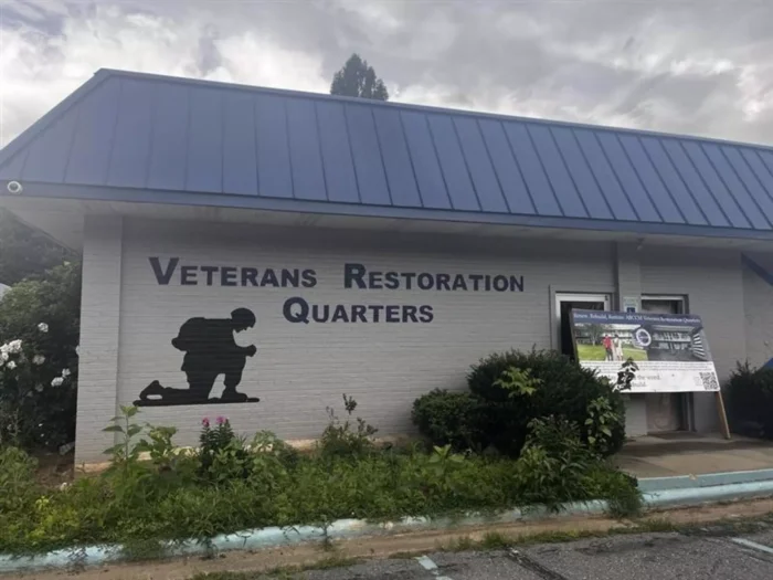 A building with the words "Veterans Restoration Quarters" on the side of the building. 