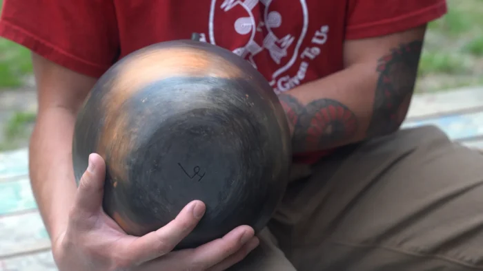 A person holding a piece of pottery.