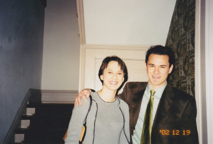 An older photograph of two young people standing in a dorm room.