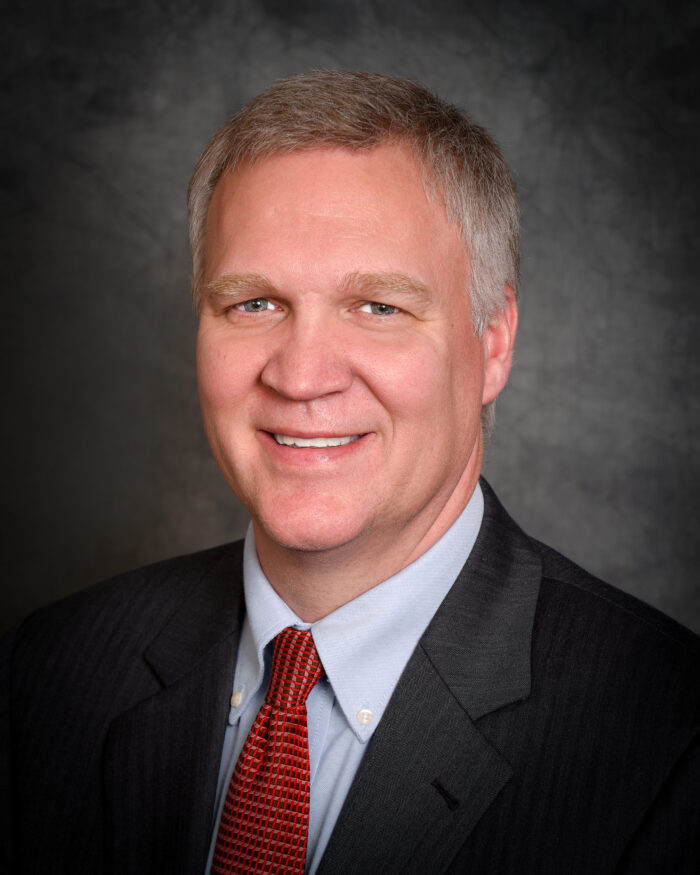 A headshot of an adult man with gray hair.