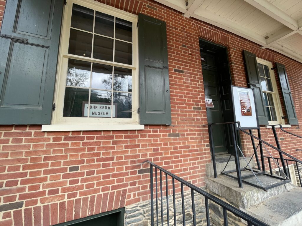 A brick building with a sign in a window that reads, "John Brown Museum."