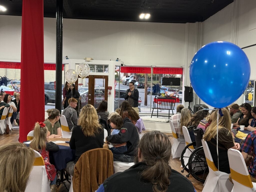 Man standing looking at crowd holding a microphone
