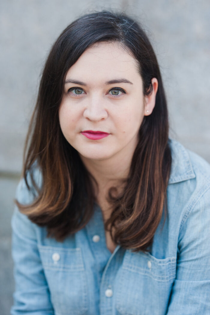 A portrait image of white woman with brown hair wearing a blue shirt.